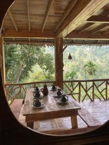 a wooden table with vases on top of a porch at Treehouse in Ella