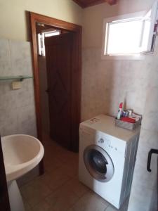 a bathroom with a washing machine and a sink at 56s.m comftorable studio,airport area in Anemómylos