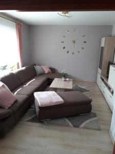 a living room with a couch and a clock on the wall at Ferienhaus Nr.7 in Winsen +39 photos