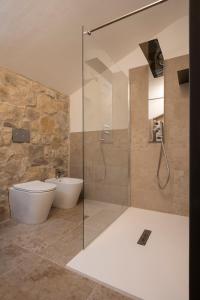 een badkamer met een glazen douche, een toilet en een wastafel bij SnowLake Suite & Apartment in Alleghe
