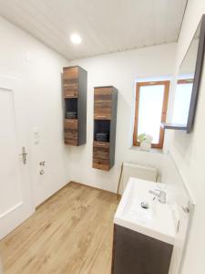 baño con lavabo blanco y ventana en Appartments am Waldbad - Unterm Nussbaum, 