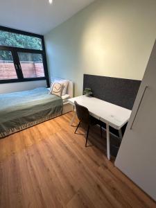 a bedroom with a bed and a desk and a window at Traumhafte Architekten-Doppelhaushälfte in Unterschleißheim +6 photos