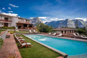 a resort pool with chairs and mountains in the background at Gocta Andes Lodge in Cocachimba