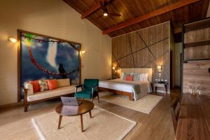 a bedroom with a bed and a couch and a table at Gocta Andes Lodge in Cocachimba