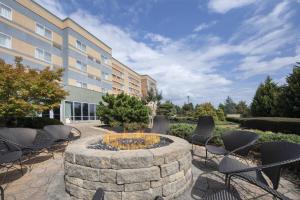 a courtyard with chairs and a fire pit in front of a building at Courtyard Atlanta McDonough in McDonough