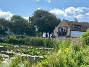 a house and a pond with lily pads at Boutique Studio Apartment By My Getaways in Rottingdean