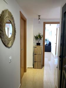 a hallway with a mirror on the wall and a table at Evasion in Miami Platja