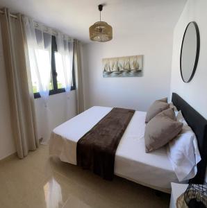 a bedroom with a bed with white sheets and a mirror at Evasion in Miami Platja