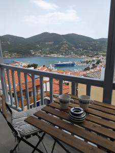 a balcony with a table and two cups of coffee at The Botanist Guesthouse in Skopelos Town