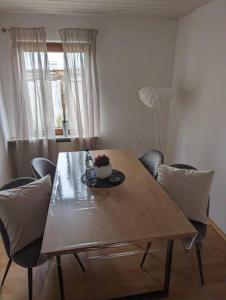 a dining room table with chairs and a bowl of flowers on it at Heufelsen Ferienwohnung in Hinterweidenthal +8 photos