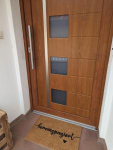 a wooden door with a mat in front of it at Heufelsen Ferienwohnung in Hinterweidenthal