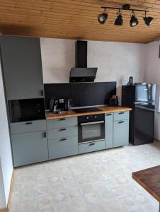 a kitchen with stainless steel appliances in a room at Heufelsen Ferienwohnung in Hinterweidenthal