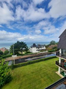 a view of the yard of a house with a river at le cottage vue mer in Bénerville-sur-Mer