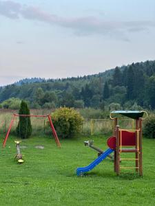 a playground with a slide and a swing at Domek u Pilota in Ropienka