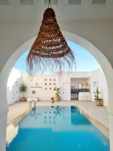 un lustre suspendu au-dessus d'une piscine dans une maison dans l'établissement Villa Sans Vis à Vis Le Domaine Luxury Experience, à Mezraya