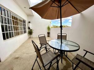 un patio con mesa, sillas y sombrilla en Departamento para seis personas en Etzatlán. en Etzatlán