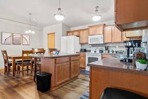 uma cozinha com armários de madeira, uma mesa e uma sala de jantar em Convenient Townhouse - Near Airport em Rapid City