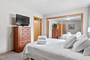 1 dormitorio con 1 cama grande y espejo en Convenient Townhouse - Near Airport, en Rapid City