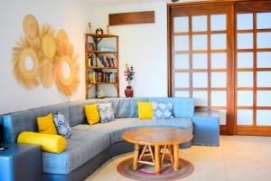 a living room with a blue couch and a table at Casa de Ali: Located on the beach! in Zihuatanejo