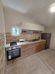 a kitchen with wooden cabinets and a sink and a refrigerator at Superb Apartments Virpazar in Virpazar