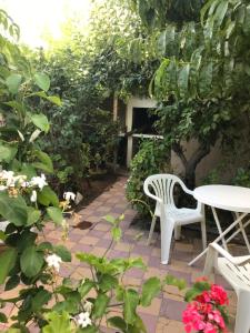 un patio con una silla blanca y algunas flores en La casa de la Abuela en San Rafael