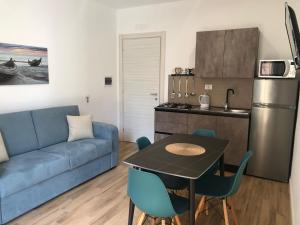 a living room with a couch and a table and a kitchen at Charme Apartments in Trapani