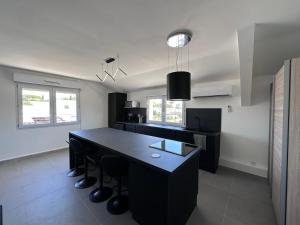 een keuken met een zwart eiland in een kamer bij Design Therapy in Lavérune