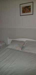 a bed in a bedroom with a picture on the wall at Villa Vintage in Tammela