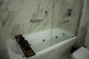 y baño con bañera y ducha acristalada. en DEPARTAMENTO ENTERO CON SERVICIOS excelente en Buenos Aires