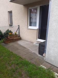a patio outside of a house with a window at Słoneczny apartament z małym ogródkiem in Wejherowo