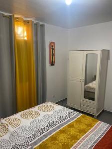 1 dormitorio con cama, tocador y espejo en Villa Caïmite, en Rémire-Camp