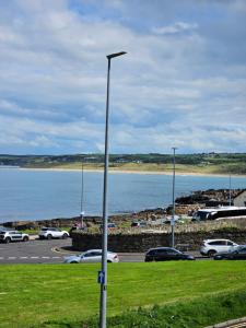 a street light in a parking lot next to a body of water at Saltwater Edge Apartment in Portrush