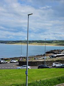 a street light in a parking lot next to a body of water at Saltwater Edge Apartment in Portrush