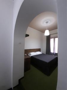 a bedroom with a black bed and a window at B&B Domus Enna in Enna