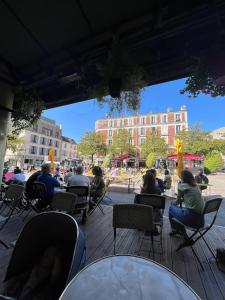 eine Gruppe von Personen, die auf einer Terrasse auf Stühlen sitzen in der Unterkunft Spacious flat with terrasse and parking near metro in Bagnolet