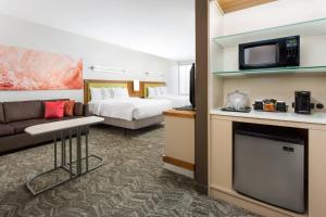 um quarto de hotel com uma cama, um sofá e uma televisão em SpringHill Suites by Marriott San Diego Mission Valley em San Diego