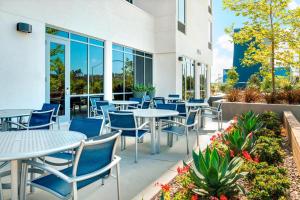 un patio avec des tables et des chaises en face d'un bâtiment dans l'établissement SpringHill Suites by Marriott San Diego Mission Valley, à San Diego