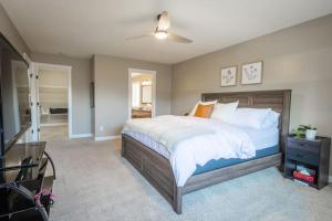 a bedroom with a large bed and a ceiling fan at Lux Haven, Sleeps 8, AC, Balcony, Close to YQL in Lethbridge