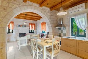 a kitchen and dining room with a table and chairs at Villa Terpsichore St George Retreat BY APOKORONAS-VILLAS in Kókkinon Khoríon