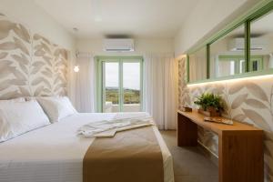 米科利维亚Plioni Villas With Private Pool & Suites With Hot Tub的一间卧室配有一张带镜子的床和窗户 更多43张照片