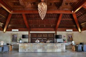 a lobby of a resort with a bar and a chandelier at Vila Ombak in Gili Trawangan