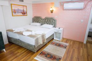 Fidelya Boutique Hotel في إسطنبول: غرفة نوم مع سرير وسجادة على الأرض