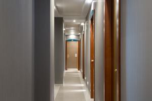 a hallway with white walls and a long aisle at Montespina Park Hotel in Naples