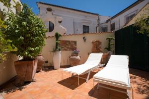 two white chairs on a patio with a house at boutique apartment al duomo in Salerno