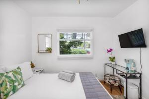 Habitación blanca con cama y TV en Cactus Room - Private Entrance en Santa Bárbara