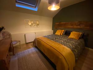 ein Schlafzimmer mit einem Bett mit gelber Bettwäsche und gelben Kissen in der Unterkunft L'ESCALE in Quiévrain