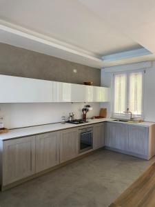 a large kitchen with white cabinets and a window at ORO, 8 in Bellano