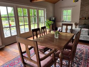 een eetkamer met een houten tafel en stoelen bij Guesthouse 't Oeyenbos in Knegsel