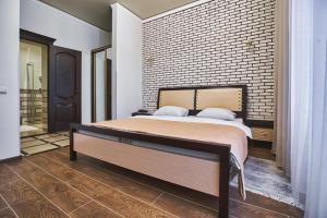 - une chambre avec un lit et un mur en briques dans l'établissement Ангел комфорт, à Kiev
