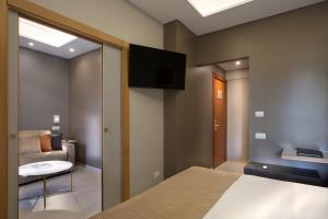 a bedroom with a bed and a couch and a tv at Montespina Park Hotel in Naples
